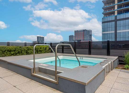 A small pool with a metal ladder sits on a patio.