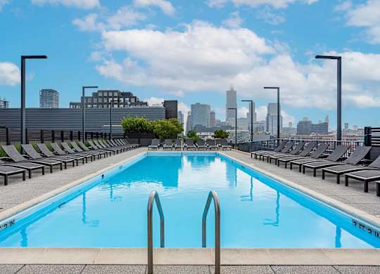 A swimming pool with a city skyline in the background.