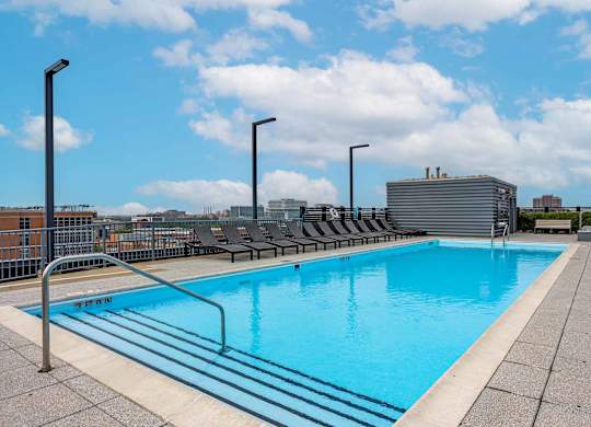 A large outdoor swimming pool with a metal railing around it.