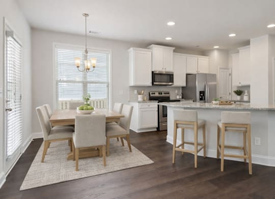 A view of the spacious kitchen, dining area, and stainless steel appliances