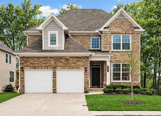 A house with a brown brick facade and a white garage door.