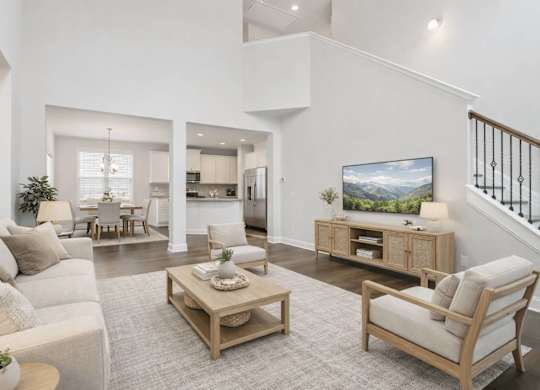A living room with a white couch, a wooden coffee table, and a TV on a cabinet.