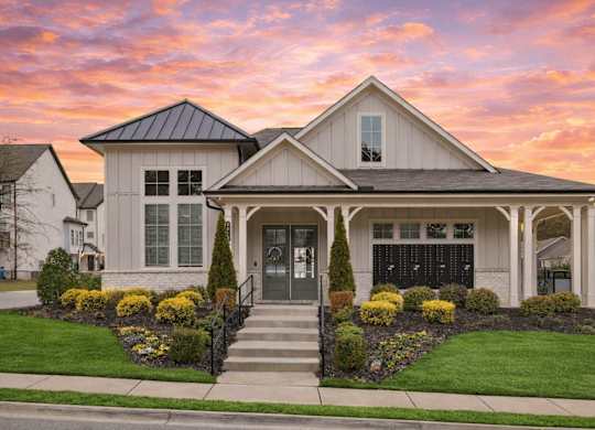 A house with a front yard and a black fence.