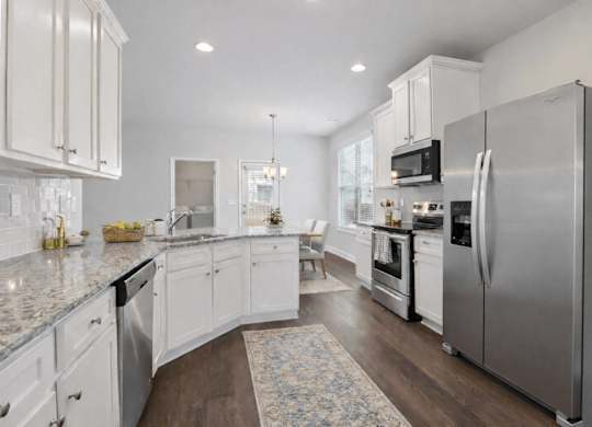 A kitchen with white cabinets and a large island.