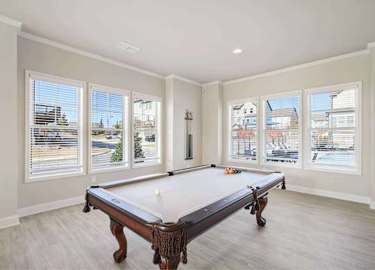 A pool table in a room with a view of the city.