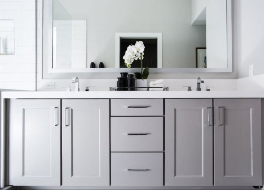 a bathroom with white cabinets and a sink and a mirror at Novella Arcadia, Arizona