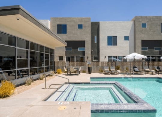 a swimming pool with chairs and a building in the background at Novella Biltmore, Phoenix, 85016