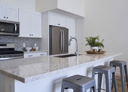 a kitchen with bar stools and a granite counter top at Novella Biltmore, Phoenix, AZ
