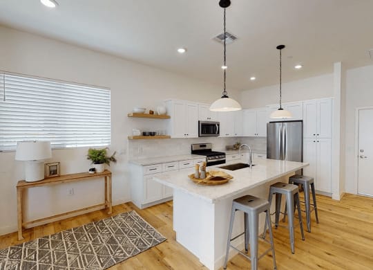 a kitchen with a large island with bar stools at Novella Biltmore, Phoenix, AZ 85016