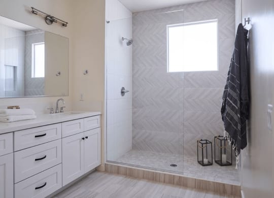 a white bathroom with a shower and a sink and a mirror at Novella Biltmore, Arizona