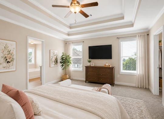 A bedroom with a large bed and a ceiling fan.
