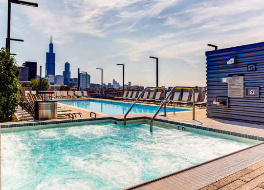 Warming rooftop spa with a hot tub, lap swimming pool and view of the Chicago skyline at The Madison at Racine, Chicago