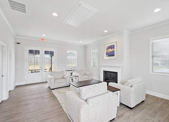 Upscale clubhouse lounge centered around a cozy fireplace.