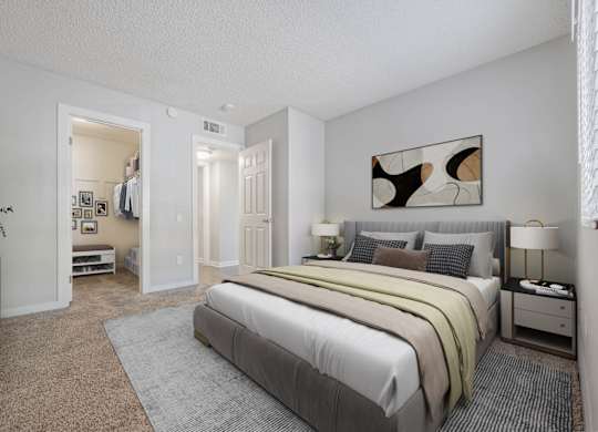 A bedroom with a large bed and a painting on the wall.