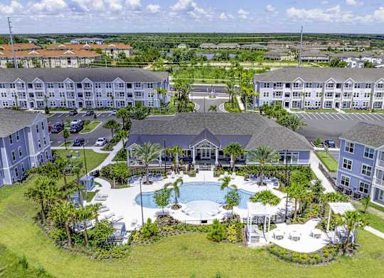 A large resort with a pool and palm trees.