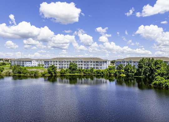an apartment building overlooking a lake on a sunny day