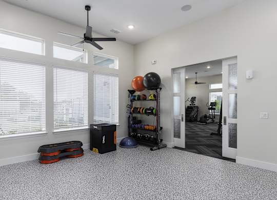 a living room with a large window and a ceiling fan