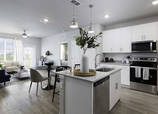 a kitchen and living room with white cabinets and a counter top