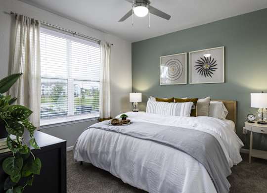 a bedroom with a large bed and a ceiling fan