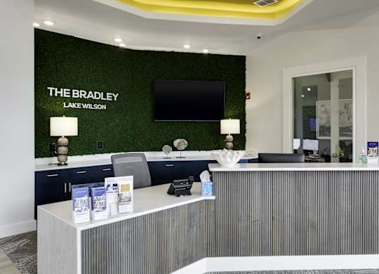 the law firm reception desk with green turf wall behind it