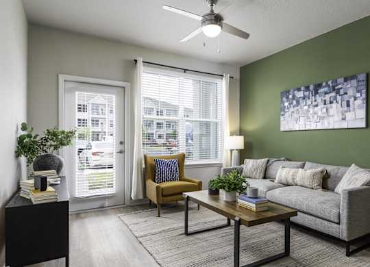 a living room with green walls and a ceiling fan