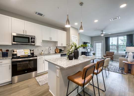 A modern kitchen with white cabinets and a large island.