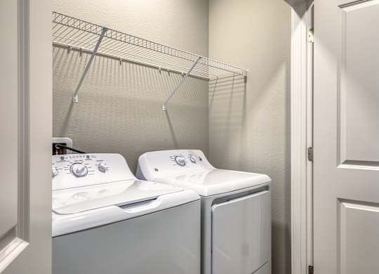 Two white washing machines in a laundry room.