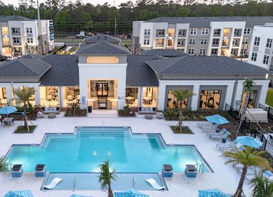 A large white building with a pool in front.