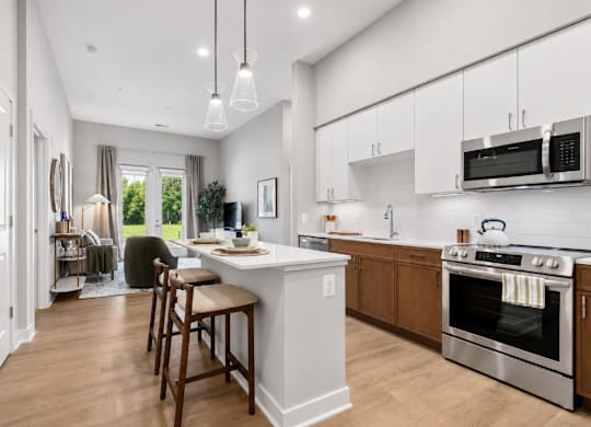 A modern kitchen with a white island and stainless steel appliances.