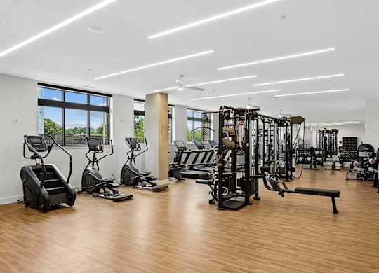 A gym with a variety of equipment including treadmills, weights, and exercise machines.