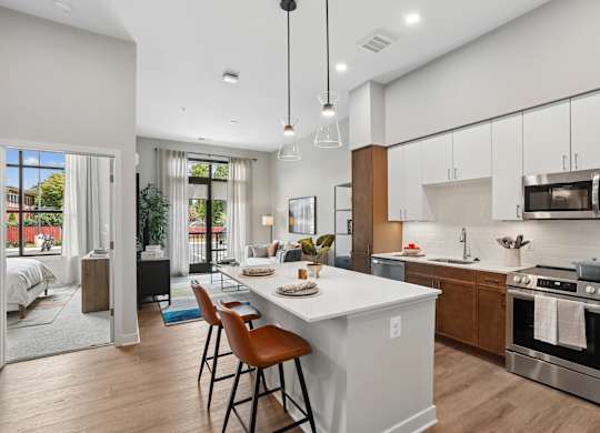 A modern kitchen with a white island and wooden cabinets.