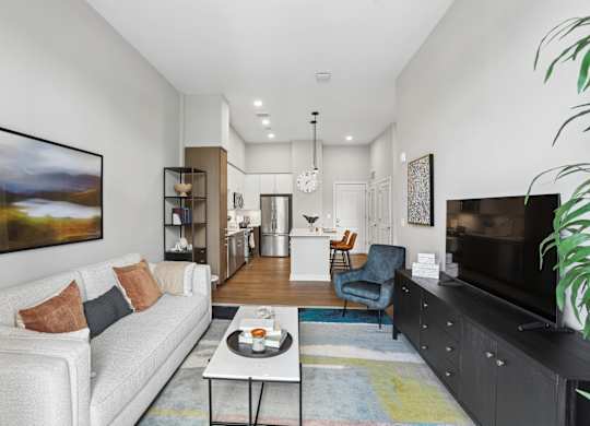 A living room with a white couch and a painting on the wall.
