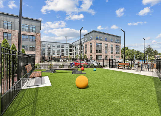 A playground with a green lawn and a yellow ball.