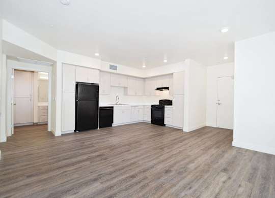 an empty room with white walls and wood floors