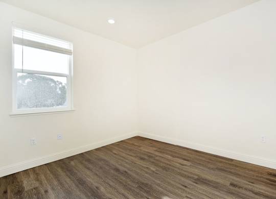 an empty room with white walls and a window