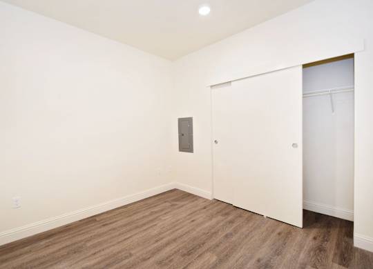 an empty room with white walls and wooden floors