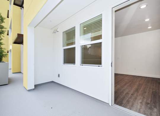 an empty room with white walls and a glass door