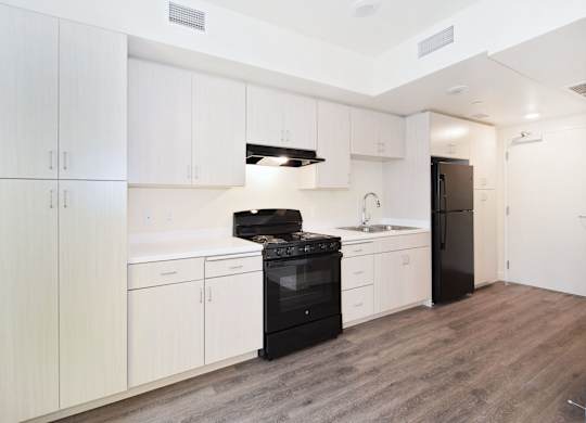 A kitchen with white cabinets and a black stove top oven.