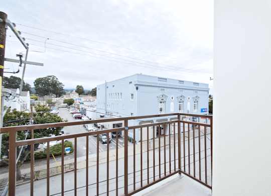 A white building with a brown railing in front of it.