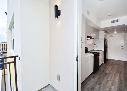 A modern kitchen with white cabinets and a black stove top oven.