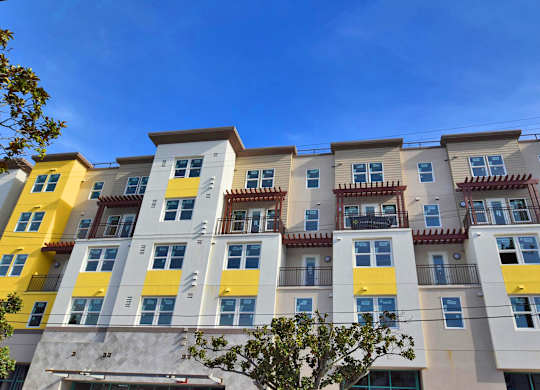 a typical apartment building with yellow and white facade