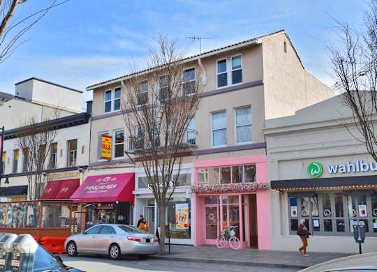 A street view of a city with a Wahbu storefront.