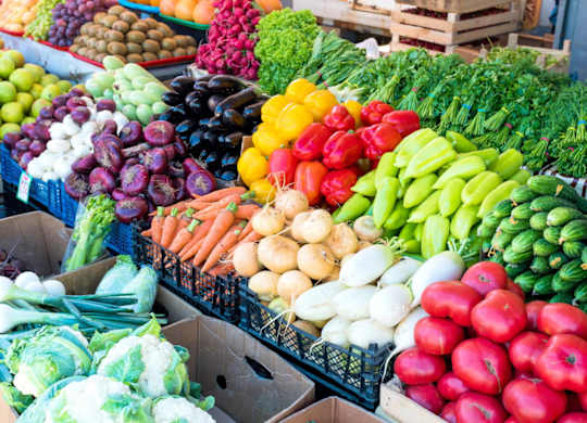 A variety of fresh vegetables are displayed at a market.