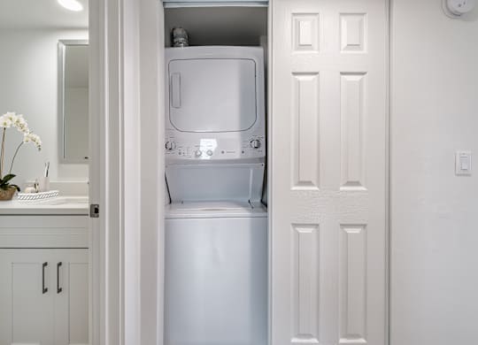 A white refrigerator is in a kitchen with a white door.