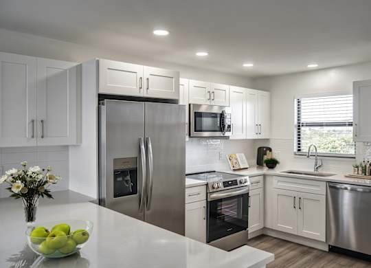 a kitchen with stainless steel appliances and white cabinets