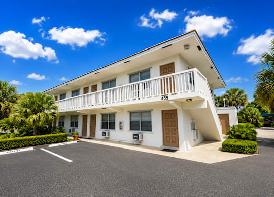 459 - A white two-story building with a balcony on the second floor.