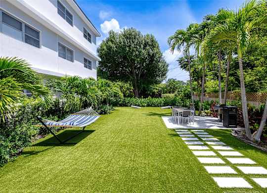 A white building with a lawn in front of it.