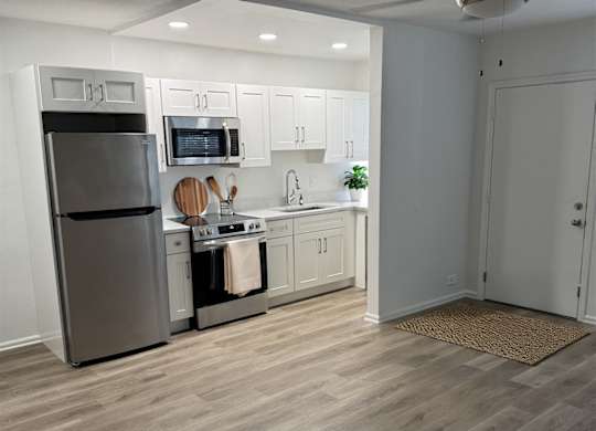 A kitchen with a refrigerator, stove, and oven.