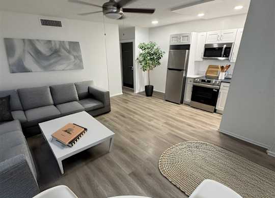 A modern living room with a grey couch and a white coffee table.