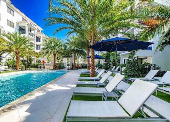 a pool with lounge chairs and an umbrella